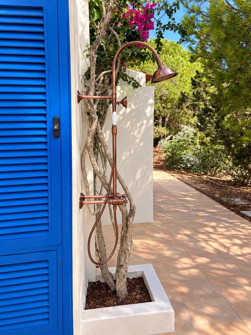 Outdoor shower next to a blue shutter